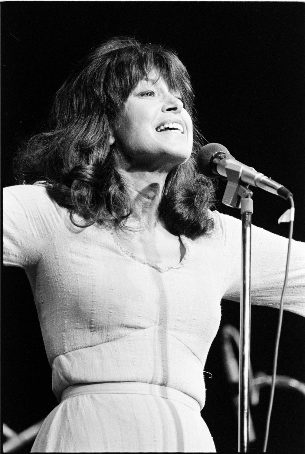 Pauline Julien chantant devant un micro sur scène.