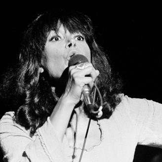 Photo en noir et blanc de Pauline Julien chantant sur scène